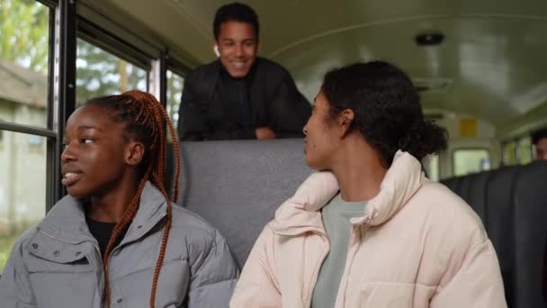 Due ragazze diverse in chat mentre cavalcano scuolabus — Video Stock