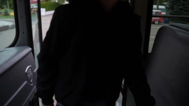 Çok ırklı öğrenciler otobüse binerken basamakları tırmanıyor.
