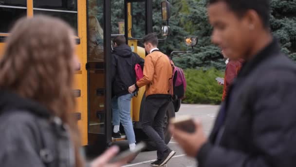 Autobús escolar recogiendo estudiantes después de los estudios — Vídeo de stock