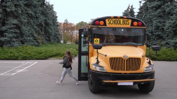 Estudiantes multinataionales bajándose del autobús escolar — Vídeo de stock
