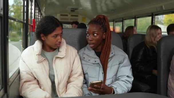Красивые девушки с помощью телефона во время езды школьный автобус — стоковое видео