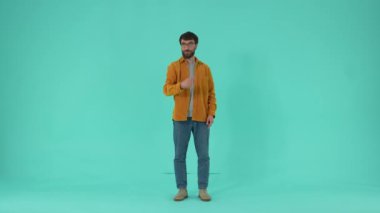 Gülümseyen adam onun önünde parmakla işaret ediyor ve tabanca gibi yan yatarken jestleri olan seyirciyi büyük tekliflere, reklamlara, online alışveriş konseptine dikkat etmeye davet ediyor.