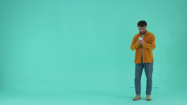 Soustředěný Vousatý Muž Při Pohledu Obrazovce Mobilních Telefonů Zatímco Čeká — Stock video