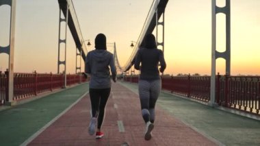 Sabahları kentin yaya köprüsünde koşan formda Müslüman kadınlar görülüyor. Arkadaş canlısı meslektaşlar açık havada spor yapıyor, sağlıklı spor yaşam tarzı kavramı.