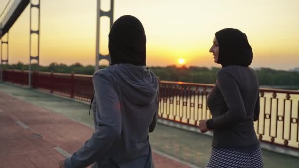 Hátsó Kilátás Sportos Muszlim Nők Hidzsábok Sportruházat Fut Város Lábhíd — Stock videók