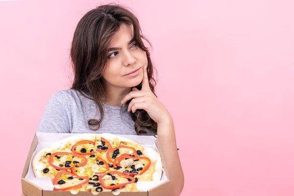 Pembe Arka Planda Bir Kutu Pizzayla Tatlı Düşünceli Kız Fotokopi — Stok fotoğraf