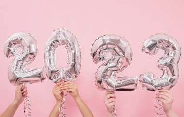 Mutlu yıllar 2023 kutlamaları. Gümüş folyo balonları. Pembe arka planda 2023 numara..