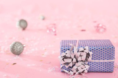 Noel oyuncaklarıyla bulanık pembe arkaplanlı bir Noel hediyesinin yakın çekimi, kopyalama alanı.