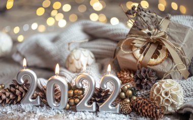 Noel arkaplanı, 2022 sayıları şeklinde mumlar yakarak dekor detaylarıyla bulanık bir arkaplanda ve bokeh.