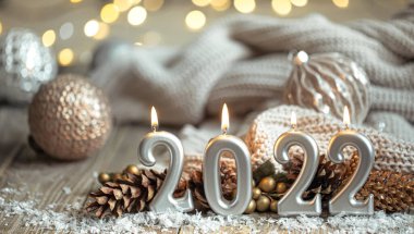 Noel arkaplanı, 2022 sayıları şeklinde mumlar yakarak neşeli dekorlu bulanık bir arkaplan ve bokeh.