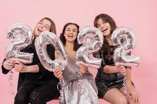为了庆祝新的一年 一群穿着粉色背景 头戴银箔气球 人数为2022年的快乐女友们组成了一家公司 — 图库照片
