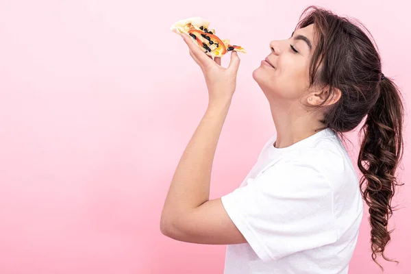 Beyaz Tişörtlü Güzel Esmer Pembe Arka Planda Bir Dilim Pizza — Stok fotoğraf