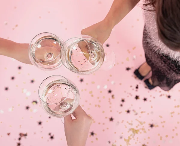 Очки с шампанским в руках девочек на вечеринке, вид сверху. — стоковое фото