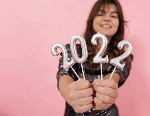 Veselá dívka na růžovém pozadí drží čísla 2022 ve svých rukou. — Stock fotografie