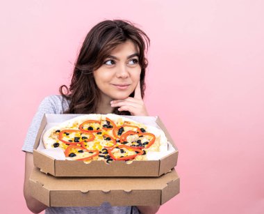Pembe arka planda pizza kutusundaki çekici kız..