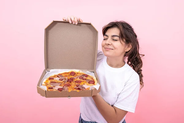 Приваблива дівчина з відкритою коробкою піци на рожевому фоні . — стокове фото
