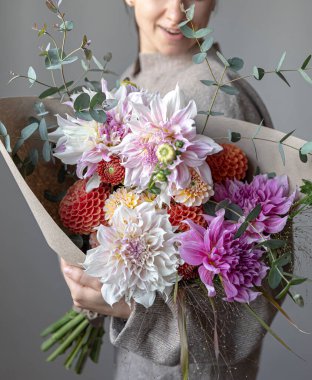 Kadın ellerinde kasımpatı olan güzel bir buketin yakın çekimi..