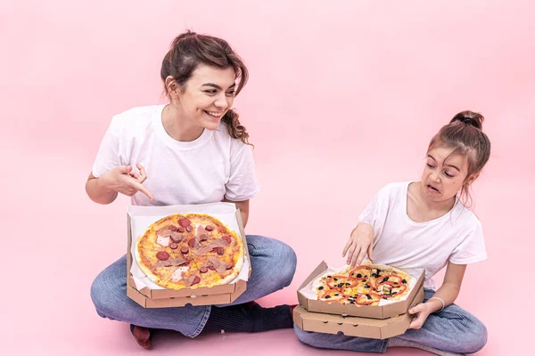 Pembe arka planda pizza paketleri olan komik kızlar.. — Stok fotoğraf