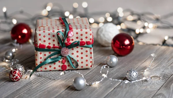 Fond de Noël avec boîte cadeau, boules sur l'arbre et lumières bokeh. — Photo