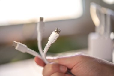 Bulanık bir arkaplanda bir cep telefonunu şarj etmek için üç farklı bağlantı.