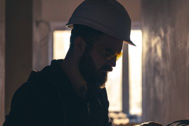 Koruyucu miğfer ve gözlüklü bir erkek müteahhit portresi..