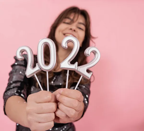 Veselá dívka na růžovém pozadí drží čísla 2022 ve svých rukou. — Stock fotografie