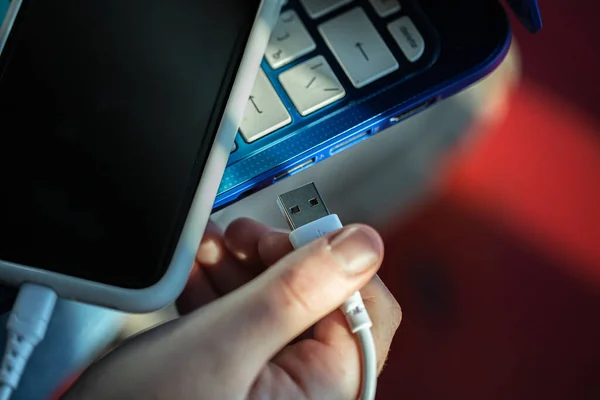 El teléfono inteligente está conectado a la computadora portátil a través del cable USB. — Foto de Stock