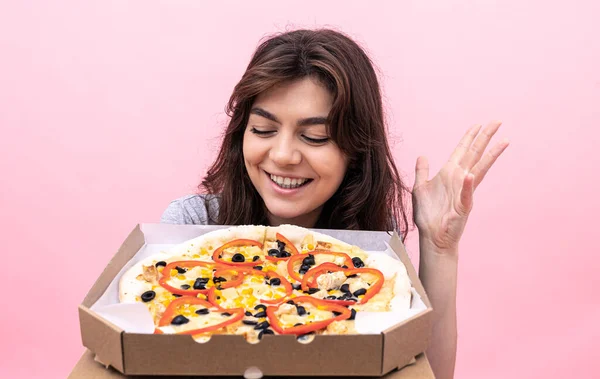 Приваблива дівчина з піцою в коробці для доставки на рожевому тлі . — стокове фото