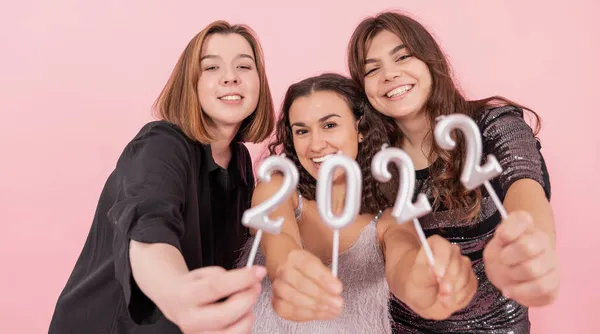 Skupina dívek drží svíčky z čísel 2022 na růžovém pozadí. — Stock fotografie