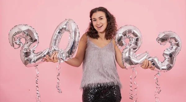 Fille gaie avec des ballons en feuille d'argent sous la forme de nombres 2023. — Photo