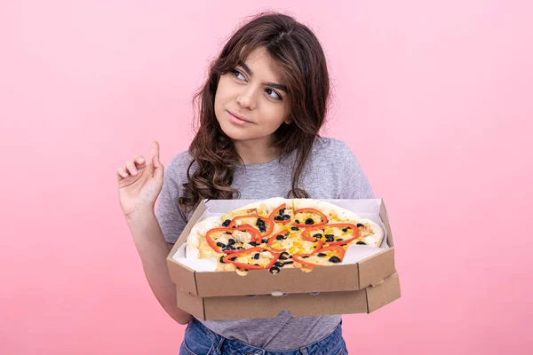 분홍색 배경으로 배달하려고 상자 안에 피자를 넣은 매혹적 인 소녀. — 스톡 사진