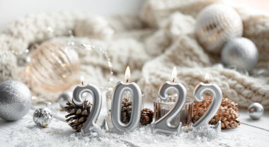 Noel şenliği arka planında 2022 numaralı mumlar var..