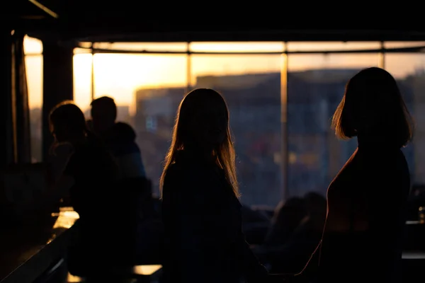 Siluete de fete care se uită pe fereastră la apusul soarelui. — Fotografie, imagine de stoc