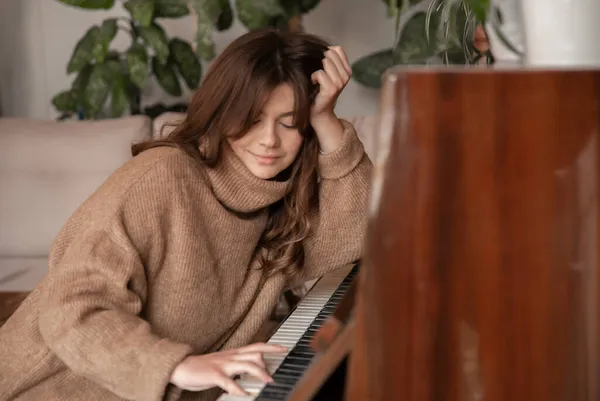 Egy vonzó fiatal nő zongorázik.. — Stock Fotó