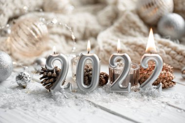 Noel şenliği arka planında 2022 numaralı mumlar var..