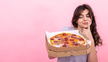 Pembe arka planda pizza kutusundaki çekici kız..