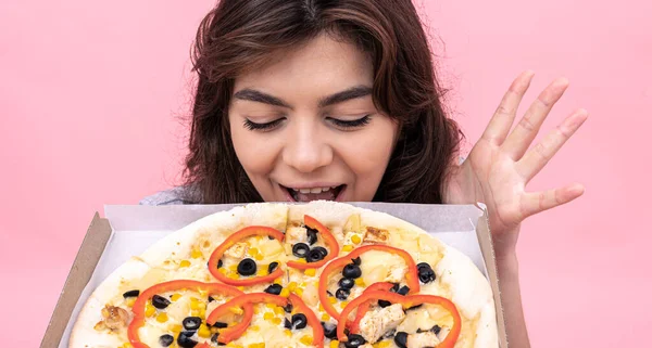 Приваблива дівчина з піцою в коробці для доставки на рожевому тлі . — стокове фото