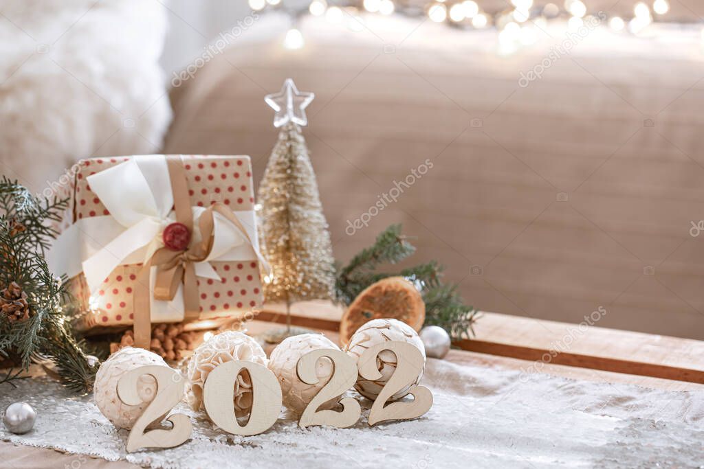Christmas composition with numbers 2022 on blurred background with bokeh.