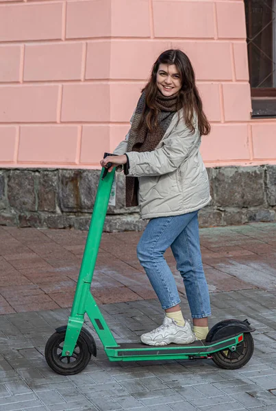 Szczęśliwa młoda kobieta na skuterze elektrycznym w mieście. — Zdjęcie stockowe
