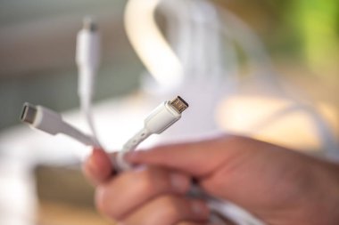 Bulanık bir arkaplanda bir cep telefonunu şarj etmek için üç farklı bağlantı.