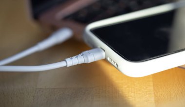 Akıllı telefon küçük beyaz bir enerji bankasından şarj edilir..