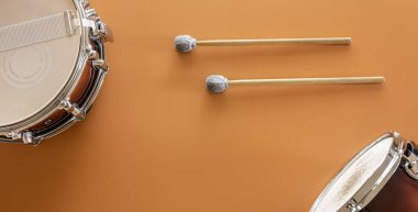 Bateri ve bagetler kahverengi arkaplanda, üst görünümde.