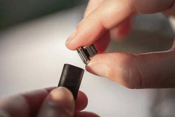 El cable USB es plegable con un accesorio magnético en la mano. — Foto de Stock