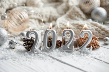 Noel şenliği arka planında 2022 numaralı mumlar var..