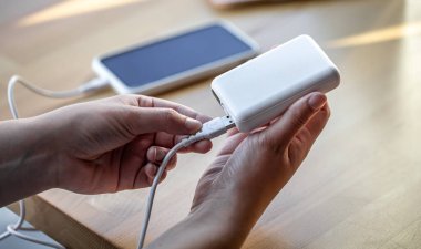 Beyaz USB kablo ve beyaz güç bankasını tutan kadınlar..