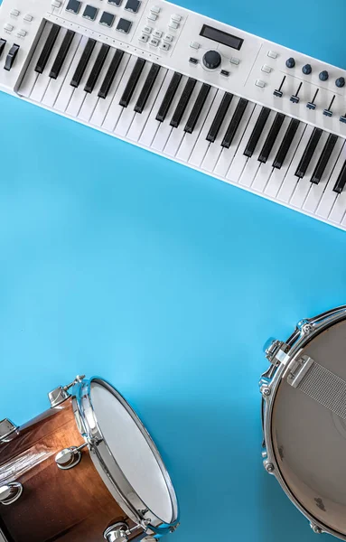 Μουσικά πλήκτρα και τύμπανα σε μπλε φόντο, επίπεδη lay, αντίγραφο χώρου. — Φωτογραφία Αρχείου