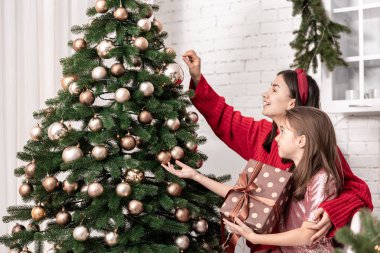 Anne ve küçük kızı Noel ağacını birlikte süslemişler..