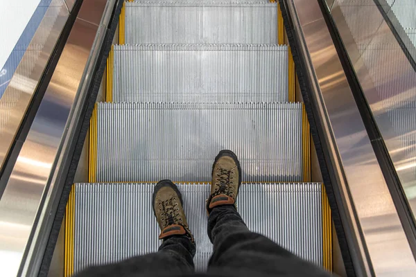 Männliche Füße auf der Rolltreppe, Draufsicht. — Stockfoto