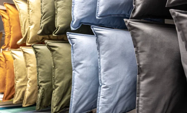 Текстильные подушки разных цветов на прилавке в магазине. — стоковое фото