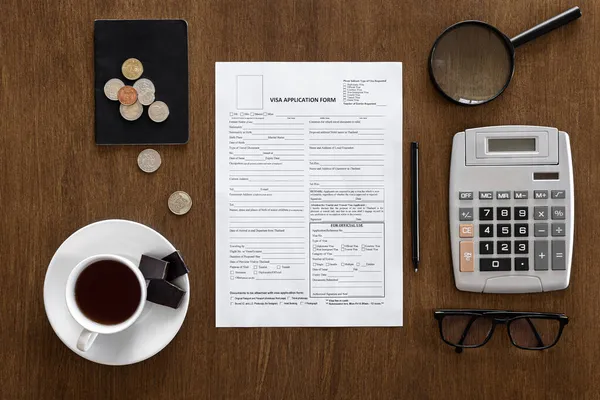 Visa application form on a wooden table, visa processing, registration, flat lay